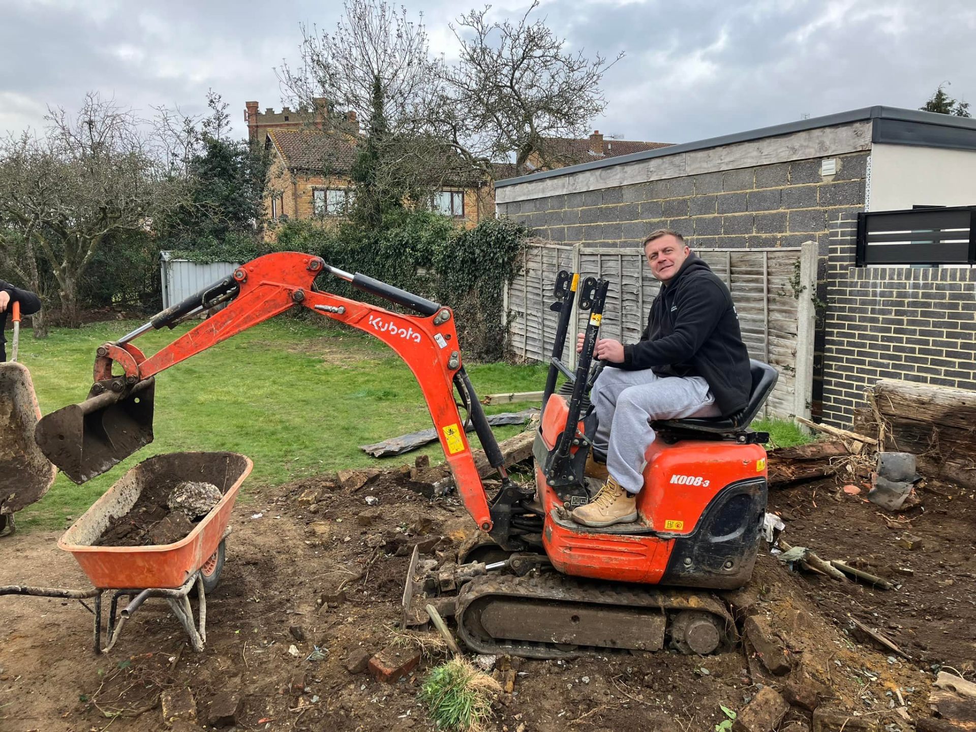 Craig operating mini digger for garden groundwork