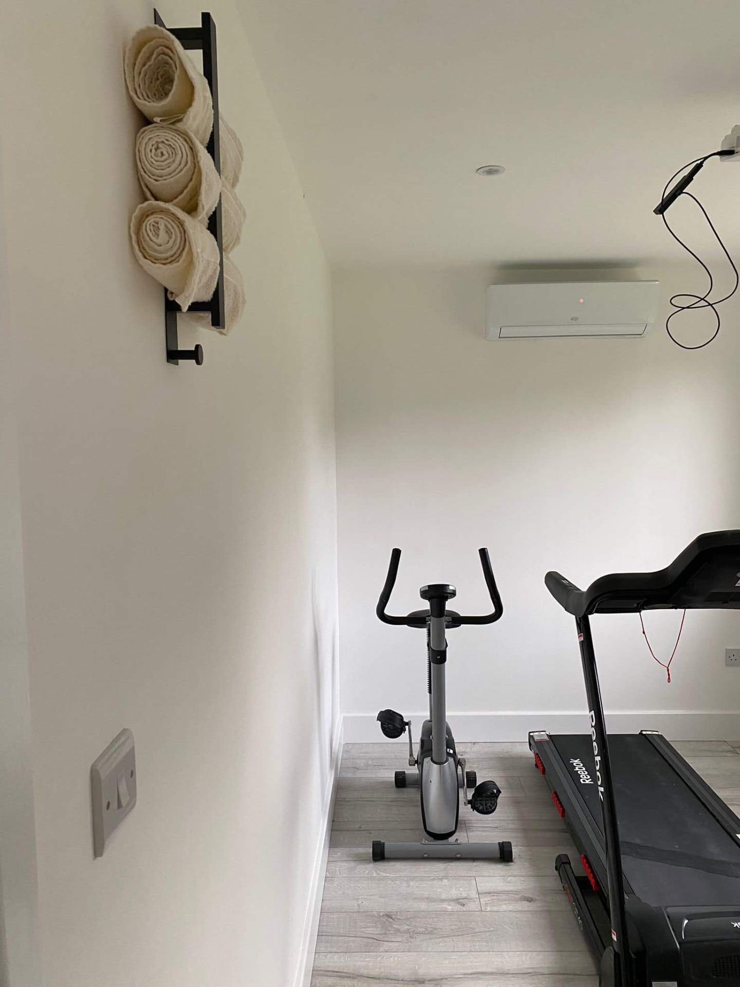 Home gym with mounted equipment and towel rack